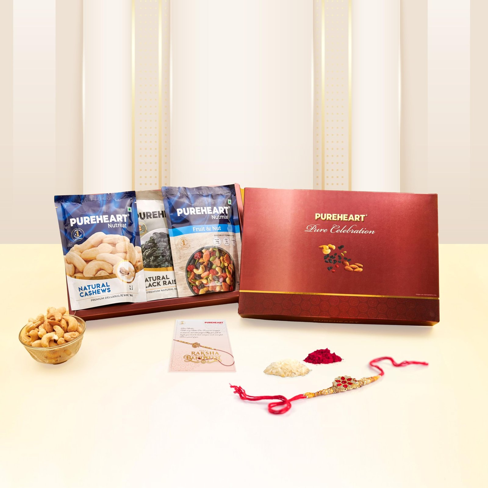 81oL9C9mljL.jpg PUREHEART Rakhi Gift Hamper- Natural Cashews, Fruit & Nut Nutmix and Black Raisins (80g, each) with Floral Rakhi for Brother, Gift Card, Pooja Rice, Kumkum - Dry Fruits Gift for Rakshabandhan - Fast Shipping to USA & Canada - Image 1